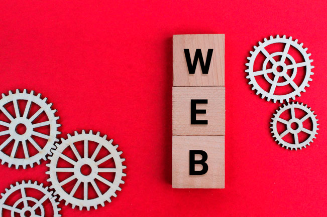 Imagen con bloques formando la palabra web y engranes que representan estructura web seo y optimizacion tecnica digital.