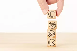 Bloques de madera con iconos digitales representan los canales de contacto integrados en estrategias de Google Ads de Sidci Empresarial.