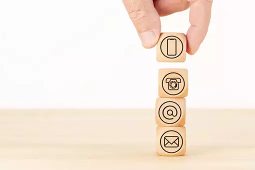 Bloques de madera con iconos digitales representan los canales de contacto integrados en estrategias de Google Ads de Sidci Empresarial.